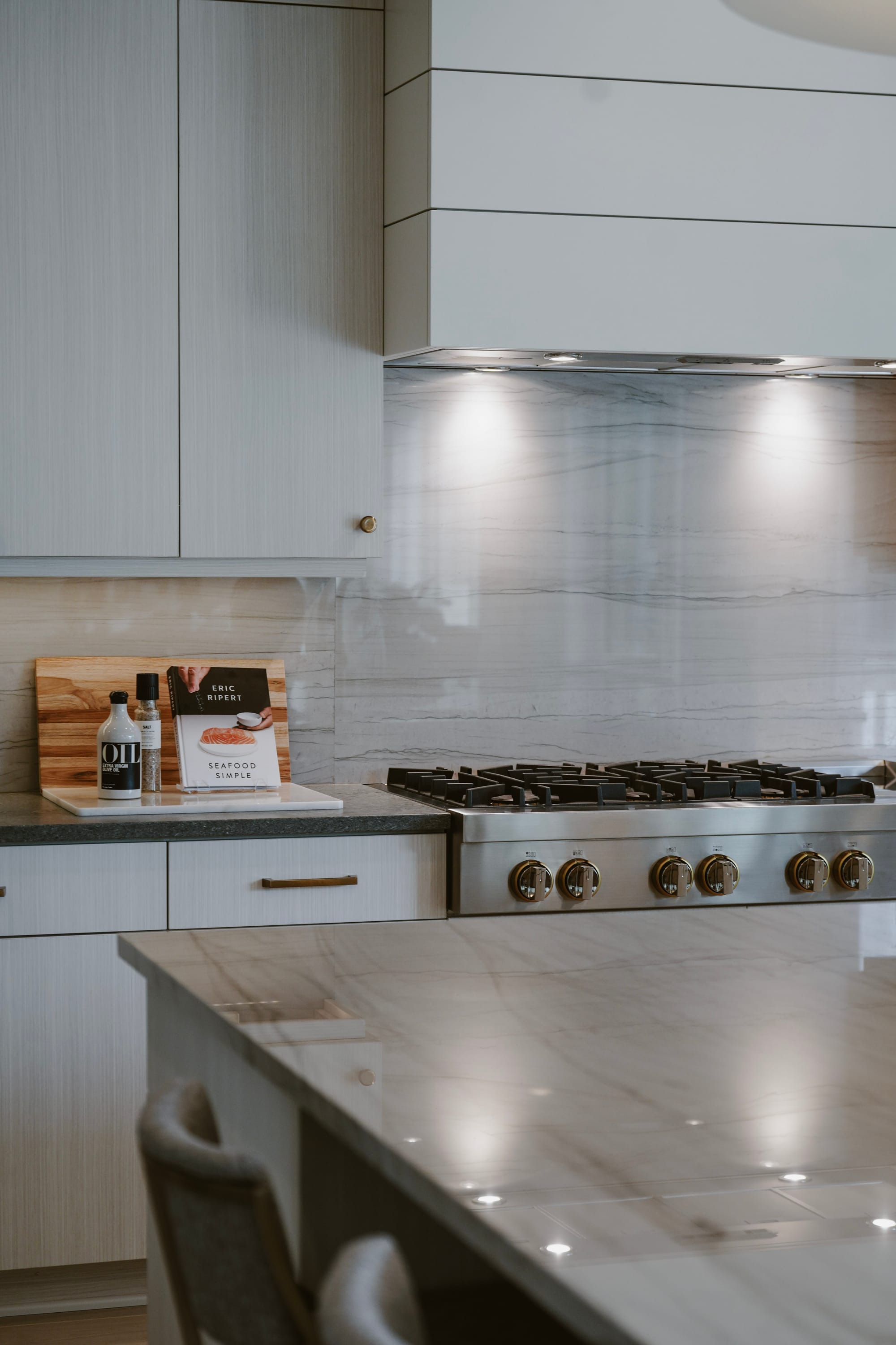 Bright modern kitchen with marble backsplash and gas range